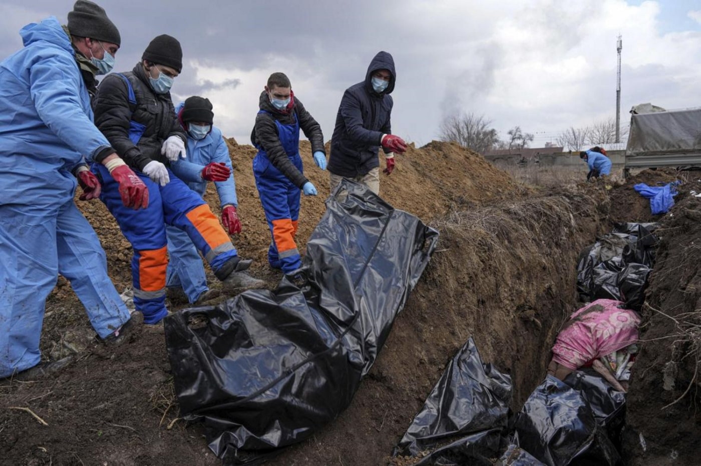 Bodies are placed into a mass grave on the outskirts of Mariupol. The heavy shelling by Russian forces is preventing people from burying their dead EVGENIY MALOLETKA - AP
